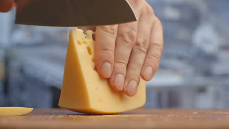 Cut-yellow-holey-cheese-on-a-wooden-board-closeup.-shred.
